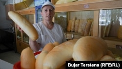 Një shitëse duke mbajtur në dorë një bukë në një furrë në Prishtinë. Fotografi nga arkivi.