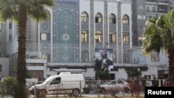 Pobunjenici ispred zgrade Ambasade Irana u Damasku 8. 12. 2024., na kojoj su pocijepani posteri lidera Hezbolaha Sajeda Hasana Nasralaha, ubijenog 27. 9. 2024., i lidera Iranske revolucionarne garde Kasema Solejmanija, ubijenog 3. 1. 2020.