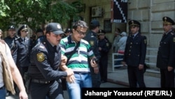 Полицейские задерживают активиста, вышедшего на акцию протеста. Баку, 6 мая 2014 года.