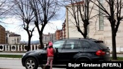 Një vajzë duke pastruar xhamat e një automjeti në Prishtinë