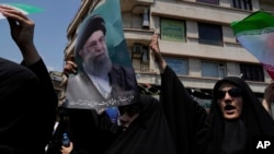 Իրան - Իսրայելի դեմ բողոքի ցույցի մասնակիցները պարզել են Գերագույն հոգևոր առաջնորդ այաթոլա Ալի Խամենեիի դիմանկարը, Թեհրան, 13-ը հունիսի, 2025թ.