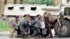 Građani i građanke Sarajeva u zaklonu od snajpera iza vojnog vozila francuskih mirovnih jedinica u centru grada, 6. jun 1995. godine