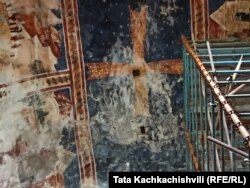 ტაძრის ცენტრალური ნაწილის ჭერი, სადაც მუქ ლურჯ ფონზე გამოსახული ჯვარი თეთრი ლაქებით დაიფარა ტაძრის ამ ნაწილის სახურავის მოჭიქულ კრამიტს ტენტი დააფარეს.