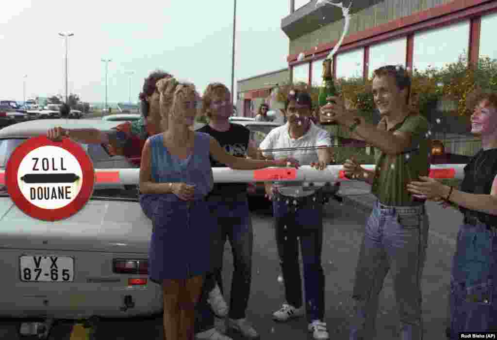 Інші святкують із пляшкою ігристого вина біля брами митниці в Нікельсдорфі, 11 вересня 1989 року