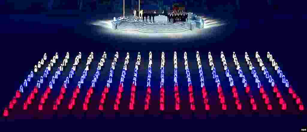 Athlete marshals with LED elements in their costumes create the colours of the Russian flag.