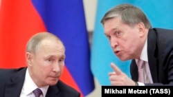Орусиянын президенти Владимир Путин (сол) жана анын жардамчысы Юрий Ушаков. Санкт-Петербургдагы жыйында. 20-декабрь, 2019-жыл.