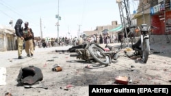 Police officers inspect the scene of a bomb blast in the border town of Chaman in the southwestern province of Balochistan on August 10.
