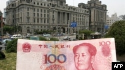 Купюра в сто юаней на фоне здания банка в Шанхае. 21 мая 2007 года.