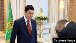 Prezident G.Berdimuhamedow egindeşlerine täze kitabyny sowgat berýär. Arhiw suraty.