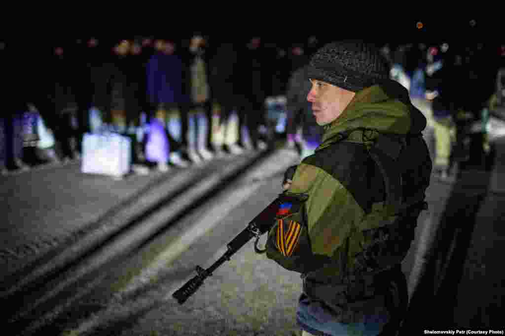 Проросійский бойовик охороняє колону українських полонених під час процедури обміну