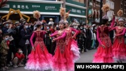 Үрүмчүдөгү базарда бийлеп жаткан кыздар. Шинжаң, Кытай. 