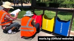 Сотрудники «Тазалыка» устанавливают сортировочные урны. Бишкек, 2 июля 2019 года.