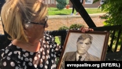 Lutfije Vokshi duke mbajtur në duar fotografinë e vëllaut të saj të zhdukur, Adem Ademi. 