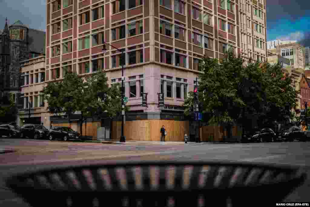 Чоловік стоїть біля крамниці захищеної дерев'яними дошками. Вашингтон, округ Колумбія, США. 1 листопада 2020 року (опубліковано 2 листопада 2020 року)