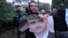 A man tears up a photo of Syrian President Bashar al-Assad in front of the Syrian Embassy in Belgrade on December 8.