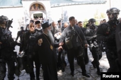 Pripadnici obezbjeđenja prate patrijarha Portfirija i vladiku Joanikija ispred manastira na Cetinju, Crna Gora, 5. septembra 2021.