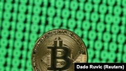 Un Bitcoin pe un ecran de computer