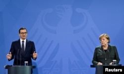 Прем'єр-міністр Польщі Матеуш Моравецький і Канцлерка Німеччини Ангела Меркель виступають на спільній прес-конференції після переговорів у Берліні, Німеччина, 25 листопада 2021 року.