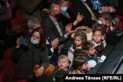 O femeie își face un selfie cu copii din Programul Cantus Mundi, în timpul spectacolului „Pe drumul Crăciunului”, la Opera Națională din București.
