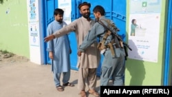Поліцейський обшукує виборця, перш ніж пропустити його до виборчої дільниці. Вибори в Афганістані, провінція Кундуз, 28 вересня 2019 року