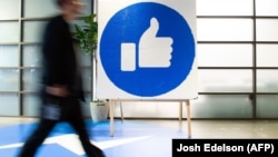 Një punëtor i Facebook-ut kalon pranë shenjës “like” të vendosur në selinë e kësaj kompanie në Kaliforni. 23 tetor, 2019.  