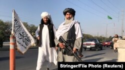 "М16" заманбап автоматын кармаган талиб согушкери шериги менен. Ооганстандын Ички иштер министрлигинин алды. 16-август, 2021-жыл.  