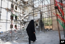 Женщина проходит через руины здания, уничтоженного израильским авиаударом 13 июня. Тегеран, 19 июля 2025 года