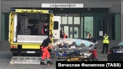 Комада жаткан Навальный атайын автоунаа менен "Шарите" ооруканасына алып келинген учур. 