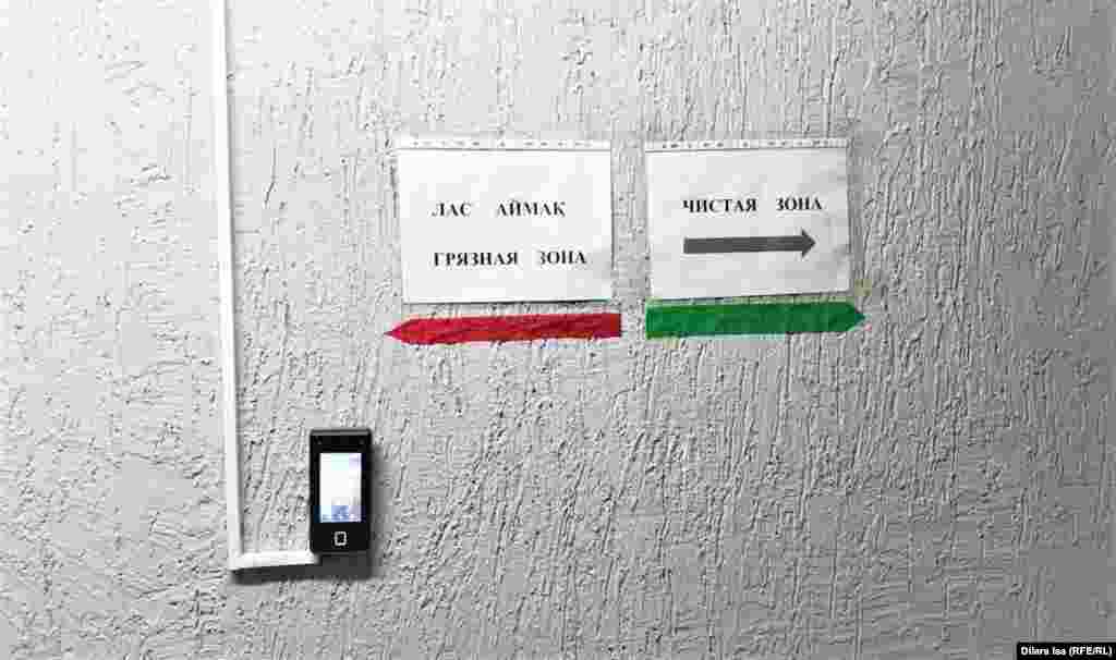 Қабырғаға қосымша "Таза аймақ" және "Лас аймақ" деп жазып қойыпты.