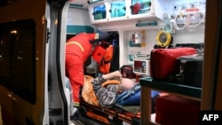 Ukrajinski spasioci pomažu muškarcu koji je ranjen u ruskom napadu dronom na naselje u Harkivu, 2. maja 2025.