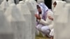 Women pray as they visit the graves of relatives at the memorial cemetery in the village of Potocari, near the town of Srebrenica in eastern Bosnia, on July 9, 2025.
