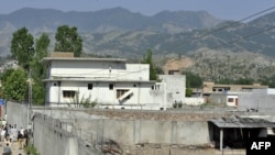 Police, reporters, and local residents gather outside Osama bin Laden's compound in Abbottabad following his death.