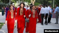 Дәстүрлі оюлары бар қызыл көйлек киген түркімен қыздары. 2017 жылғы 25 мамырда түсірілген сурет.