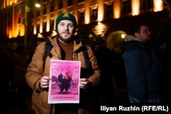 Protestuesi Alexander Karatov mban një pankartë që shkruan "Ndalojini Derrat".