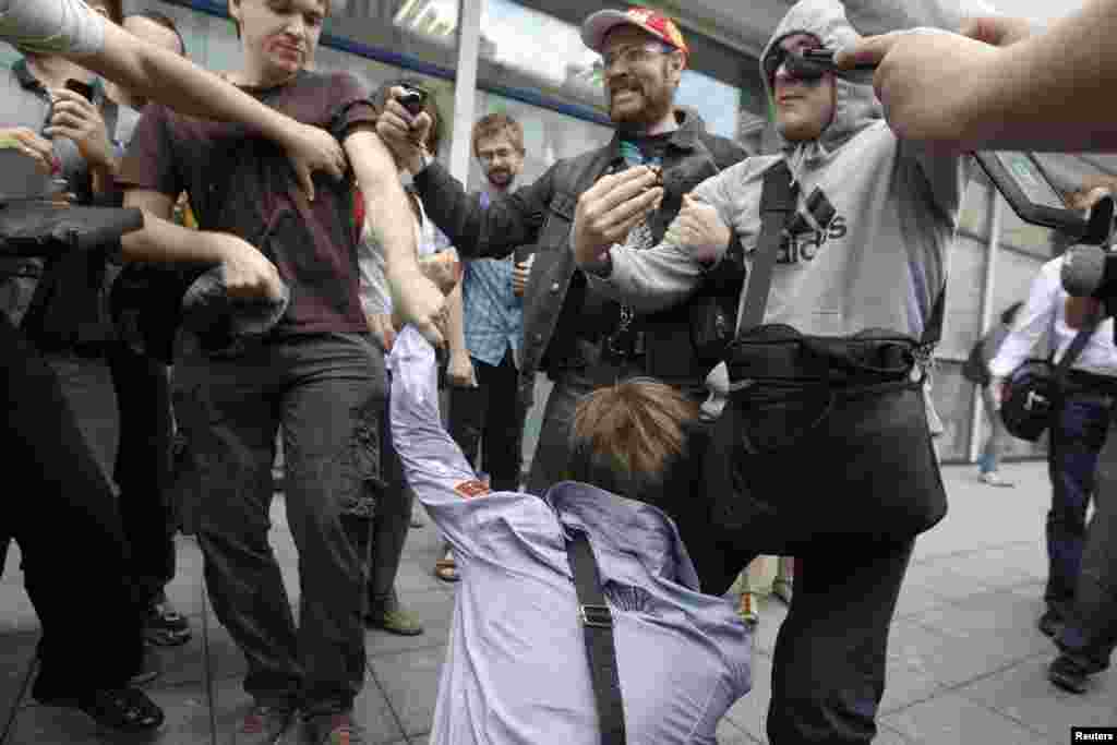 People attack a gay-rights activist in front of the State Duma.