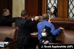 Kapitol binasynda protestçiler Wekiller öýüne girmäge synanyşýan wagty, polisiýa olara ýarag çeneýär. 6-njy ýanwar, 2021-ý.