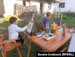 Fëmijët duke pikturuar në shkollën multietnike të pikturës.