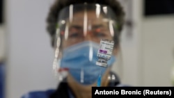 کارمند صحی واکسین آسترازنکا را برای تطبیق آماده می‌سازد April 7, 2021