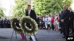 Norway's King Harald (right) and Norwegian Prime Minister Jens Stoltenberg (center) attend a wreath-laying ceremony at the site of a bomb attack that killed eight people in Oslo last year. 