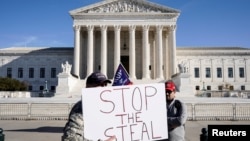 Трампты колдогон пикетчилер "Добушту уурдоону токтот!" деген талап жазылган ураанды көтөрүп турушат. Вашингтон. 2020-жылдын 11-декабры.