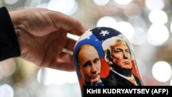 Moscova, noiembrie 2020 - Un vânzător arată o păpușă tradițională rusească din lemn, Matrioșka, care îi înfățișează pe Vladimir Putin și pe Donald Trump, într-un magazin de cadouri din centrul Moscovei.