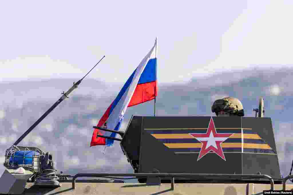 Російський стрілець на башті бронемашини на під'їзді до авіабази Хмеймім.&nbsp; &laquo;Спілкуватися із російськими солдатами неможливо&raquo;, &ndash; розповідає фотограф Бектас.&nbsp; &laquo;Вони не відповідають на запитання і не підпускають до себе близько. Вони мають напружений вигляд, але не злий, вони не застосовують жодного насильства або чогось подібного&raquo;, &ndash; додає він. &ndash; &laquo;Вони зберігають холоднокровність&raquo; &nbsp;