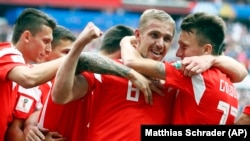 Russia's Yury Gazinsky celebrates with teammates after scoring his side's first goal during the group A match between Russia and Saudi Arabia on June 14 in Moscow. Russia won 5-0.
