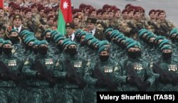 Medals jangling, Azerbaijani soldiers march in formation. Thousands of people, military and civilian, were killed on both sides of the conflict.