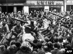 На вулицях Праги чехи блокують радянські танки, введені Варшавським договором для зміни керівництва Чехословаччини, що взяло курс на демократичні реформи. 21 серпня 1968 року