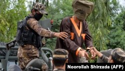 FILE: Afghanistan's National Directorate of Security (NDS) agents escort alleged Taliban and Islamic State (IS) fighters after they are presented to the media in Jalalabad on May 23.