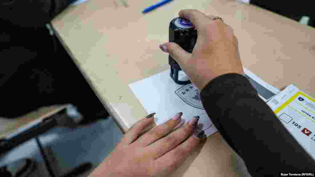 Një zyrtare e Komisionit Qendror të Zgjedhjeve e vulos fletëvotimin gjatë balotazhit për kryetar komune në kryeqytet, Prishtinë, 9 nëntor 2025.