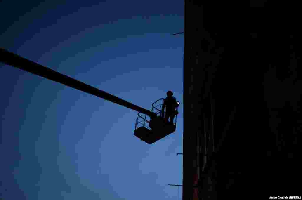 Попри те, що він поза зоною досяжності снайперів, ван Хелтен чекає настання темряви, щоби домалювати найвищі, найбільш відкриті частини муралу