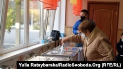 A woman puts her ballot in a box in the city of Dnipro on October 25.
