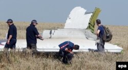 Australian and Dutch investigators examine a piece of debris of Malaysia Airlines Flight MH17 near the Ukrainian village of Hrabove.
